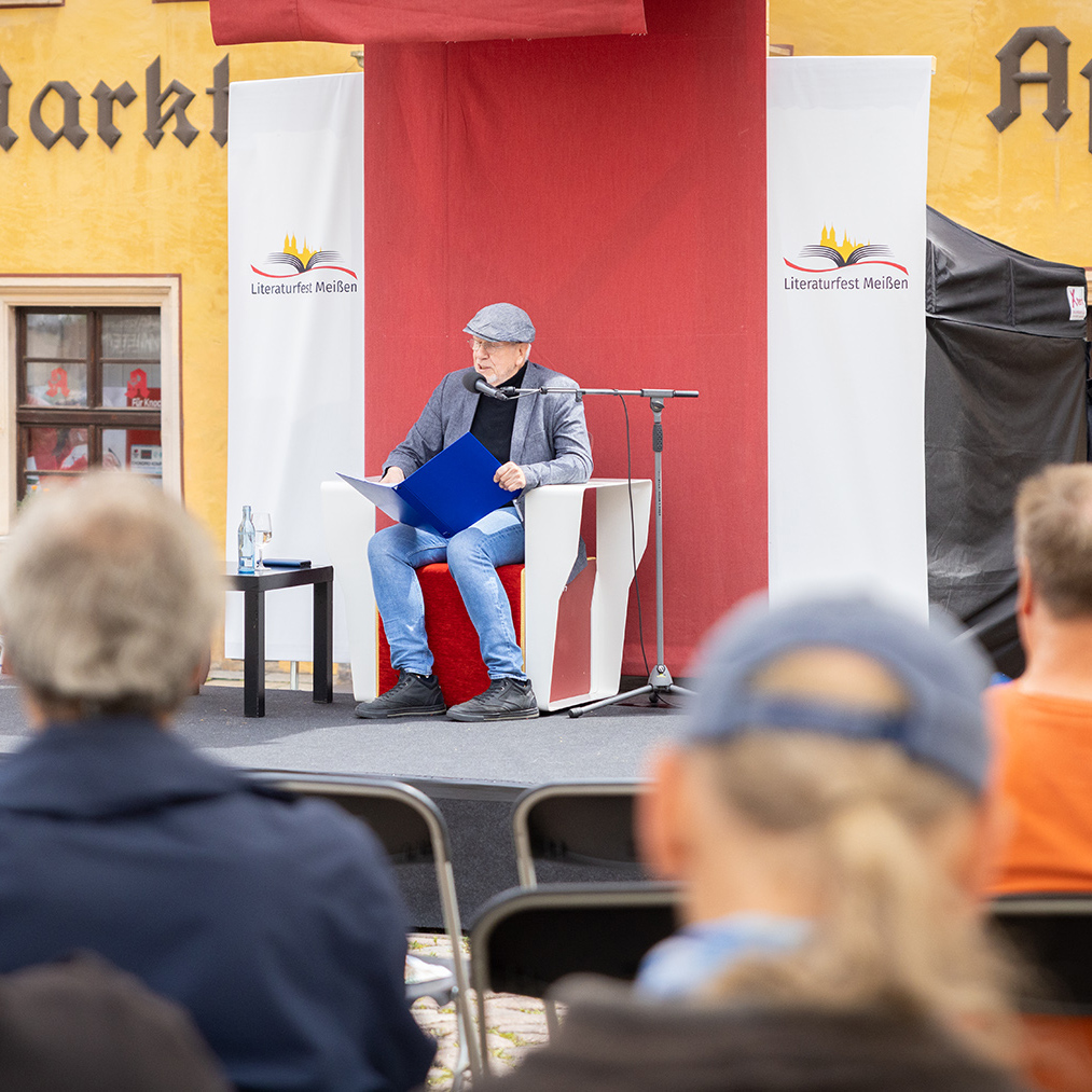 Michael Hametner lioest auf dem Marktplatz Literaturfest Meißen 2024
